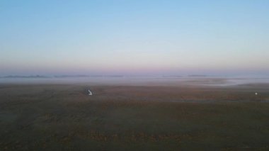 Altın gün doğumu ışığı, Mont Saint-Michel 'i çevreleyen sisli bataklıkları yansıtır. Huzurlu bir sabah atmosferinde manastırı ve köyü aydınlatır..