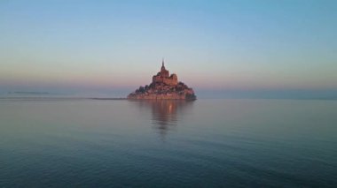 İkonik Mont Saint-Michel, kasvetli bir günde, ortaçağ köyü ve Normandiya kıyılarında sisli bir manastır ile yoğun bir siste ortaya çıkar.
