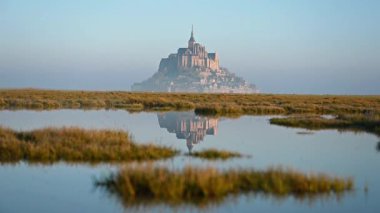 İkonik Mont Saint-Michel, kasvetli bir günde, ortaçağ köyü ve Normandiya kıyılarında sisli bir manastır ile yoğun bir siste ortaya çıkar.
