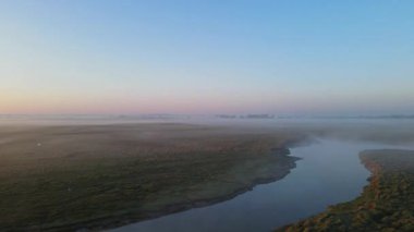 Altın gün doğumu ışığı, Mont Saint-Michel 'i çevreleyen sisli bataklıkları yansıtır. Huzurlu bir sabah atmosferinde manastırı ve köyü aydınlatır..