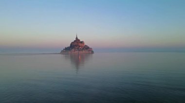 İkonik Mont Saint-Michel, kasvetli bir günde, ortaçağ köyü ve Normandiya kıyılarında sisli bir manastır ile yoğun bir siste ortaya çıkar.
