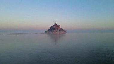 İkonik Mont Saint-Michel, kasvetli bir günde, ortaçağ köyü ve Normandiya kıyılarında sisli bir manastır ile yoğun bir siste ortaya çıkar.