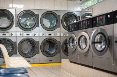 Kendi kendine hizmet eden bir çamaşırhanede, bir dizi modern çamaşır makinesi. Kullanışlı ve verimli çamaşırhane için ortak kullanım alanı.