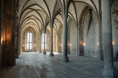 Mont Saint-Michel Manastırı 'nın sakin ve tarihi iç kısımları taş kemerler, antik duvarlar ve dar pencerelerden süzülen yumuşak doğal ışık..