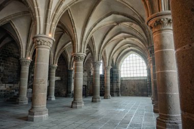 Mont Saint-Michel Manastırı 'nın sakin ve tarihi iç kısımları taş kemerler, antik duvarlar ve dar pencerelerden süzülen yumuşak doğal ışık..
