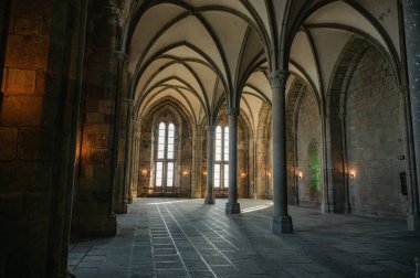 Mont Saint-Michel Manastırı 'nın sakin ve tarihi iç kısımları taş kemerler, antik duvarlar ve dar pencerelerden süzülen yumuşak doğal ışık..