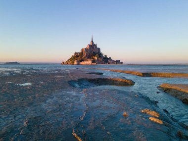 İkonik Mont Saint-Michel, kasvetli bir günde, ortaçağ köyü ve Normandiya kıyılarında sisli bir manastır ile yoğun bir siste ortaya çıkar.