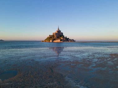 İkonik Mont Saint-Michel, kasvetli bir günde, ortaçağ köyü ve Normandiya kıyılarında sisli bir manastır ile yoğun bir siste ortaya çıkar.
