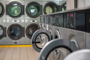 Kendi kendine hizmet eden bir çamaşırhanede, bir dizi modern çamaşır makinesi. Kullanışlı ve verimli çamaşırhane için ortak kullanım alanı.