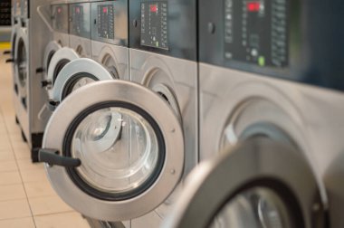 Kendi kendine hizmet eden bir çamaşırhanede, bir dizi modern çamaşır makinesi. Kullanışlı ve verimli çamaşırhane için ortak kullanım alanı.