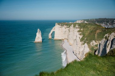 Etretat 'ın ikonik tebeşir kayalıkları ve turkuaz suları güneş ışığı altında parlayarak Normandiya' nın doğal güzelliğini ve huzurlu sahil şeridini gözler önüne seriyor..