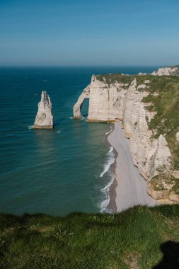 Etretat 'ın ikonik tebeşir kayalıkları ve turkuaz suları güneş ışığı altında parlayarak Normandiya' nın doğal güzelliğini ve huzurlu sahil şeridini gözler önüne seriyor..