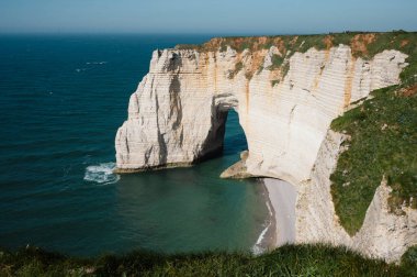Etretat 'ın ikonik tebeşir kayalıkları ve turkuaz suları güneş ışığı altında parlayarak Normandiya' nın doğal güzelliğini ve huzurlu sahil şeridini gözler önüne seriyor..