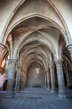 Mont Saint-Michel Manastırı 'nın sakin ve tarihi iç kısımları taş kemerler, antik duvarlar ve dar pencerelerden süzülen yumuşak doğal ışık..