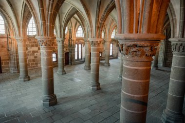 Mont Saint-Michel Manastırı 'nın sakin ve tarihi iç kısımları taş kemerler, antik duvarlar ve dar pencerelerden süzülen yumuşak doğal ışık..