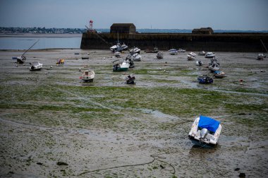 Dalgalar çekildiğinde Granville limanının manzarası. Kum ve liman duvarları üzerinde dinlenen tekneler..