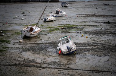 Dalgalar çekildiğinde Granville limanının manzarası. Kum ve liman duvarları üzerinde dinlenen tekneler..