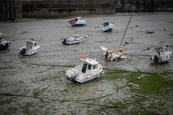Dalgalar çekildiğinde Granville limanının manzarası. Kum ve liman duvarları üzerinde dinlenen tekneler..