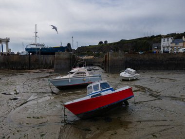Dalgalar çekildiğinde Granville limanının manzarası. Kum ve liman duvarları üzerinde dinlenen tekneler..