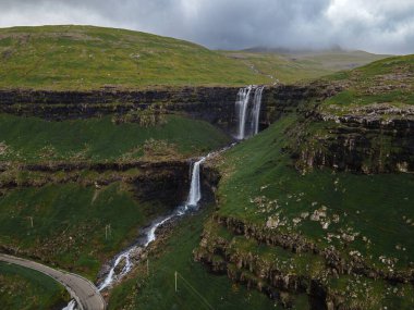 Muhteşem Fossa şelalesi, Faroe Adaları 'nın en yüksek şelalesi, Kuzey Atlantik' in engebeli kayalıklarından aşağı dökülüyor..