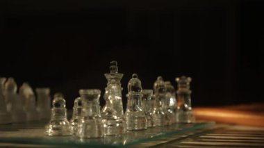 Akşam penceresi ışığında masada cam satranç oyunu