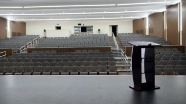 Stadyum oturma yeri ve podyumu olan bir sanat salonu sahnesi.