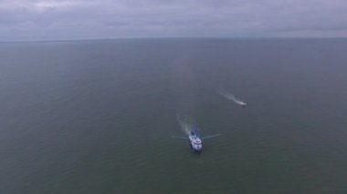 Atlantik Okyanusu 'nda açık sularda yüzen bir karides teknesinin hava üssü martılar etrafta uçarken ağlarını sürüklüyor..