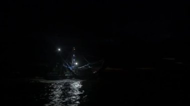 Geceleri balıkçı teknesinde balık avlarken, sudaki ağlarla..