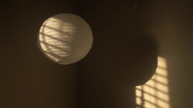 Sıcak ve rahat bir yatak odasının köşesinde pencere ışığı olan Çin fenerleri asılı.