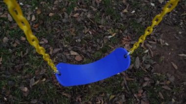 Sarı zincirden sarkan mavi salıncak