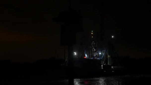 拖网渔船在夜间驶向大海时 从闪光的红色灯塔旁驶过 — 图库视频影像