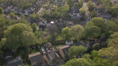 Uzun yeşil ağaçlarla çevrili huzurlu bir banliyö bölgesinin genel perspektifi