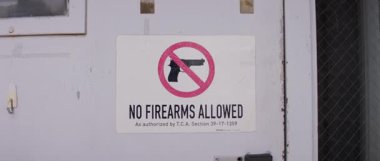 A clear sign instructing visitors that firearms are not allowed on the premises, ensuring safety.