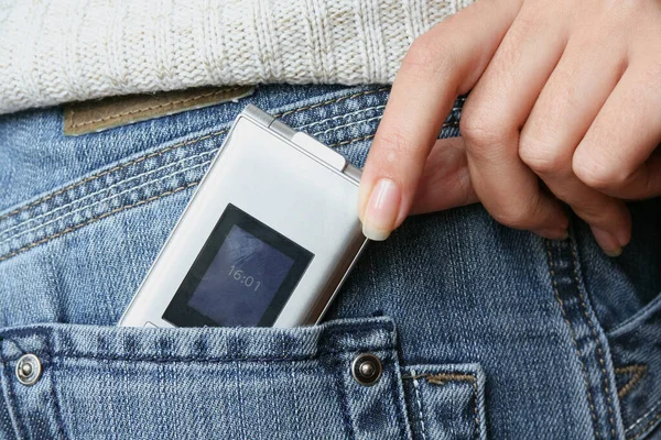 A woman's hand pulls out a phone from a man's jeans pocket.