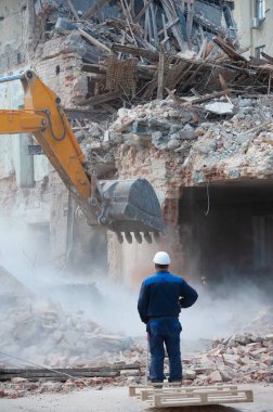 Binanın yıkımı. Kazıcı eski evi yıkıyor. Yeni bina inşaatı için yer açılıyor.
