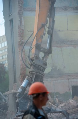 Binanın yıkımı. Kazıcı eski evi yıkıyor. Yeni bina inşaatı için yer açılıyor.