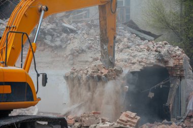 Binanın yıkımı. Kazıcı eski evi yıkıyor. Yeni bina inşaatı için yer açılıyor.