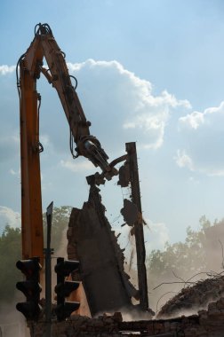 Binanın yıkımı. Kazıcı eski evi yıkıyor. Yeni bina inşaatı için yer açılıyor.