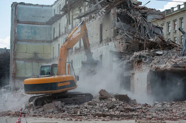 Binanın yıkımı. Kazıcı eski evi yıkıyor. Yeni bina inşaatı için yer açılıyor.