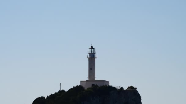 島の岬の上に建てられた灯台の距離ズームビュー — ストック動画