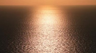 Batan güneşin arkaplanı Denize altın bir ışık saçıyor.