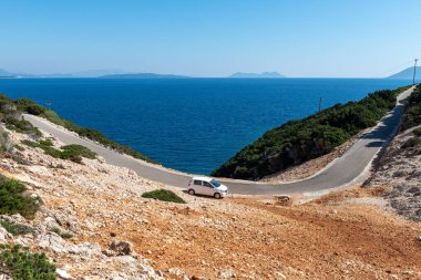 Lefkada adası. Yunanistan... 10.21.2022. Virajlı boş bir yolda bir araba. Araba keşfi tatili. Yolculuk.
