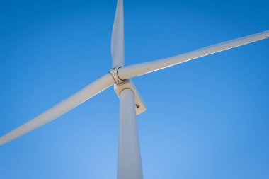 Dönen bıçakların ve bir rüzgar türbininin kafasının görüntüsünü kapat.