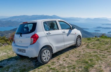 Lefkada adası. Yunanistan-10.18.2022. Bir dağın tepesinde, kıyı şeridi ve adaların enfes manzaralı bir araba..
