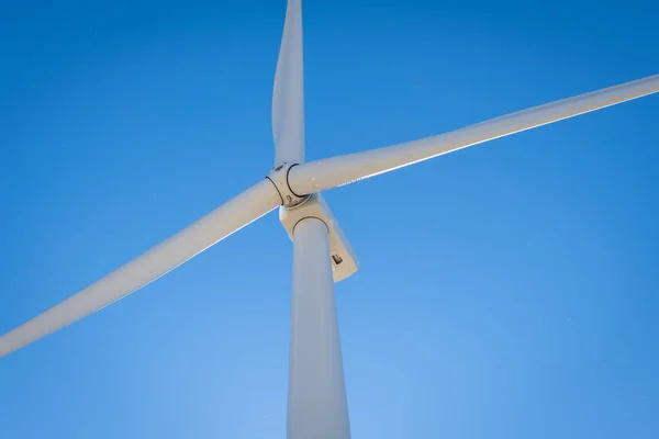 Close up view of the rotating blades and head of a wind turbine.