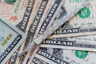 Bir sürü doların üstüne bir termometre. Sağlık hizmeti, tıbbi maliyet kavramı.