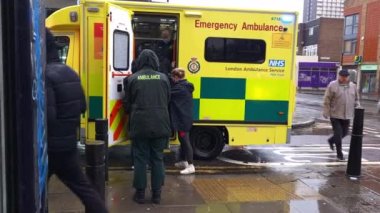 London. UK-01.10.2023. Emergency Ambulance and police on call out in response to a street incidence with paramedics helping a person into the ambulance for treatment.