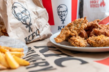 London. UK- 01.29.2023. A spread on the table of various fried chicken and potato fries from KFC online order delivery to the home.