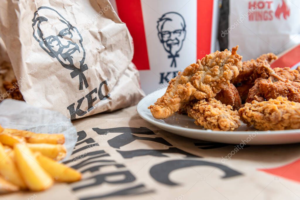 London. UK- 01.29.2023. A spread on the table of various fried chicken and potato fries from KFC online order delivery to the home.