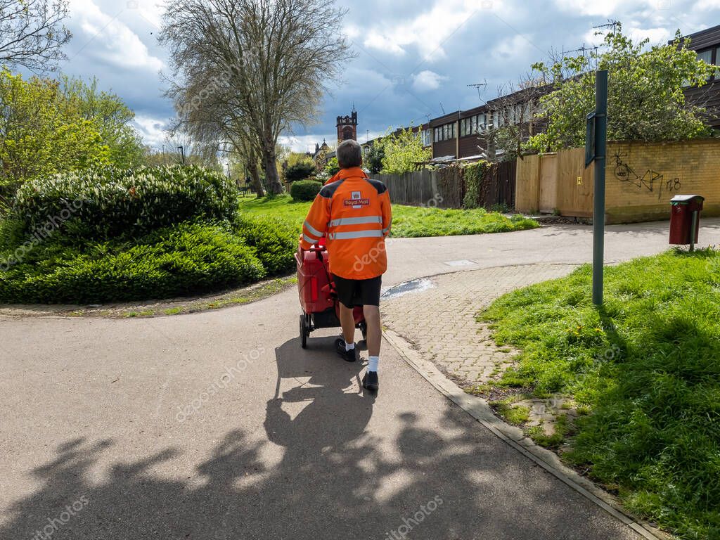 London. UK-04.28.2023. A Royal Mail postman doing his rounds on house to house postal delivery.